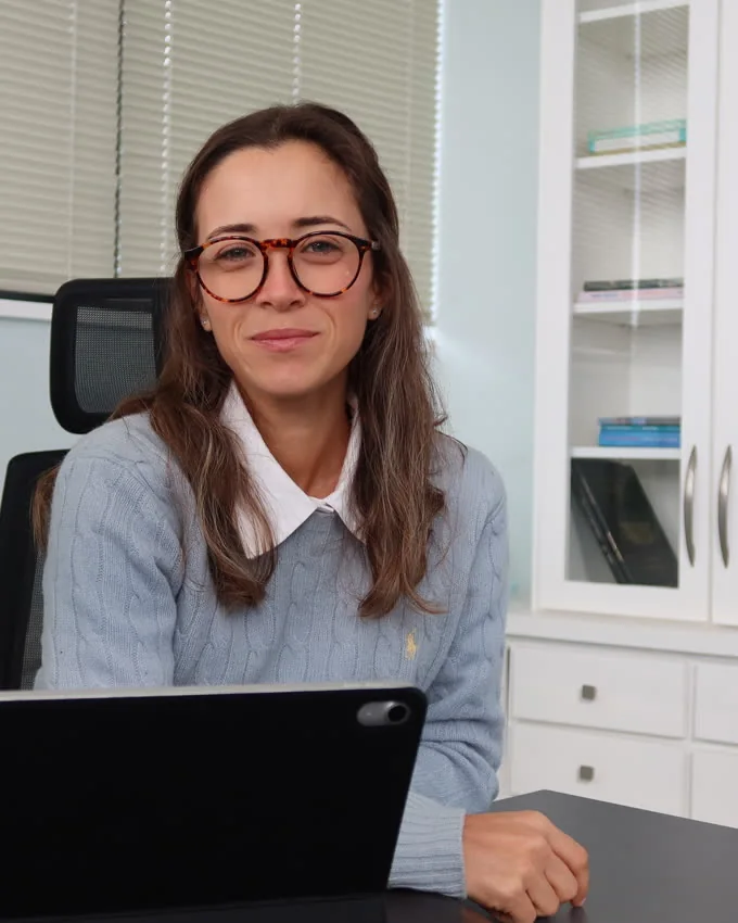 Júlia Fabris sentada em seu consultório, com expressão atenta.